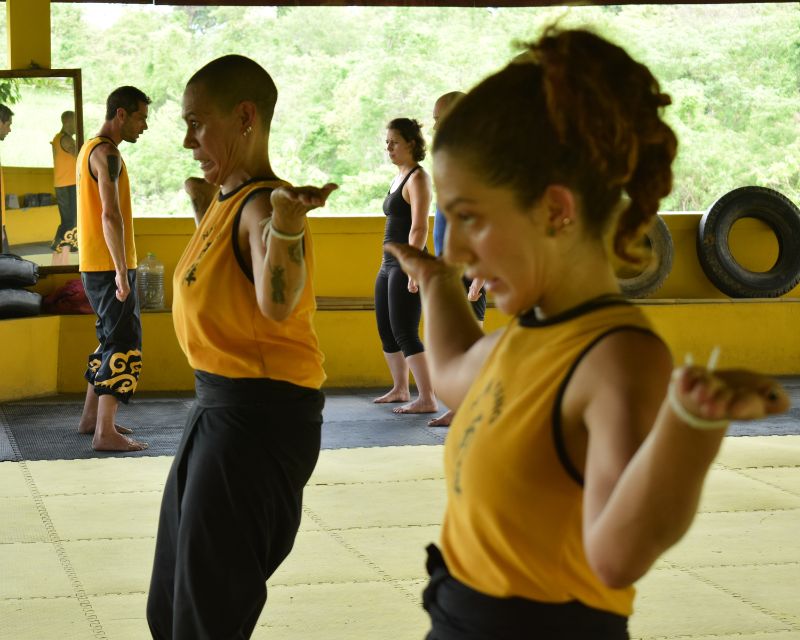 Students with their arms raised to the side performing the Vein Tendon Chi kung